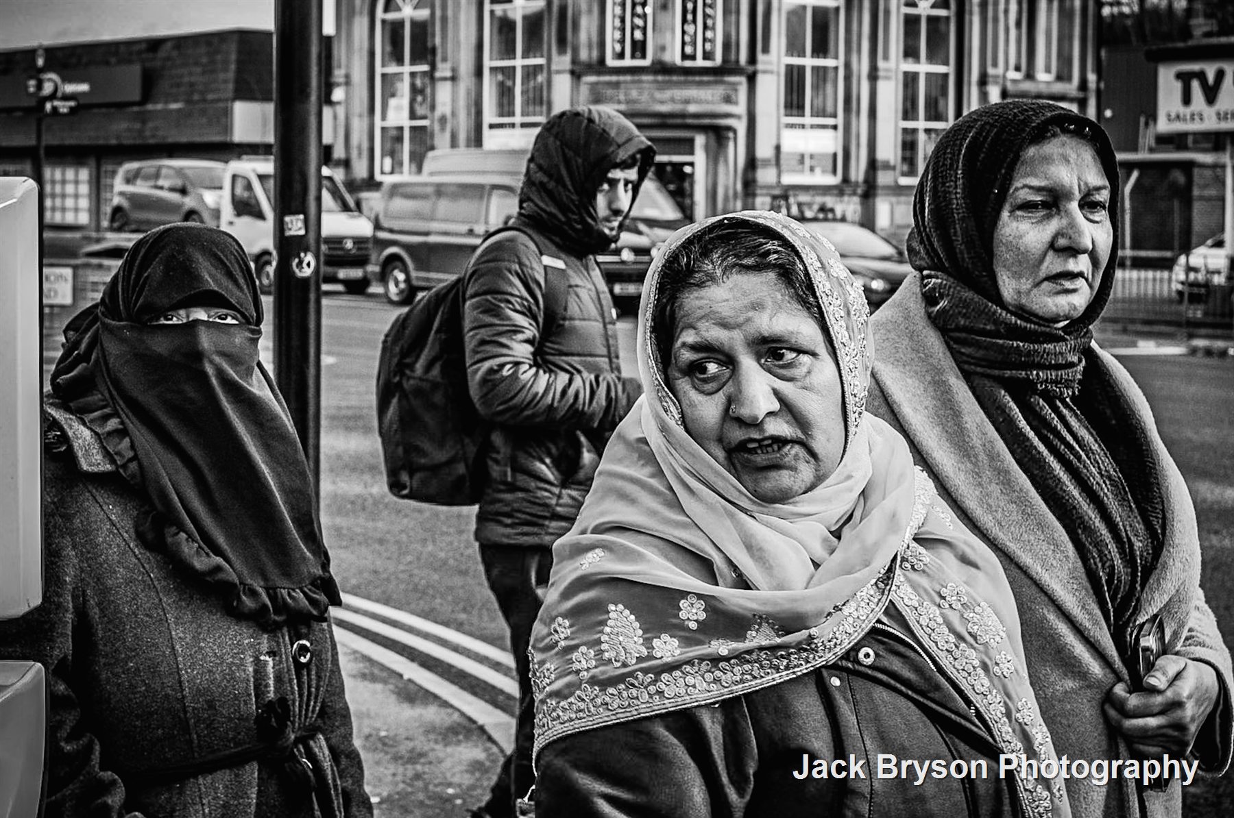 Black and white street scene with women walking through a city