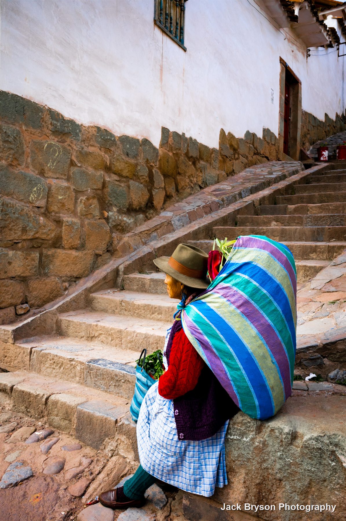 Contemplative street photograph of a person sitting on steps