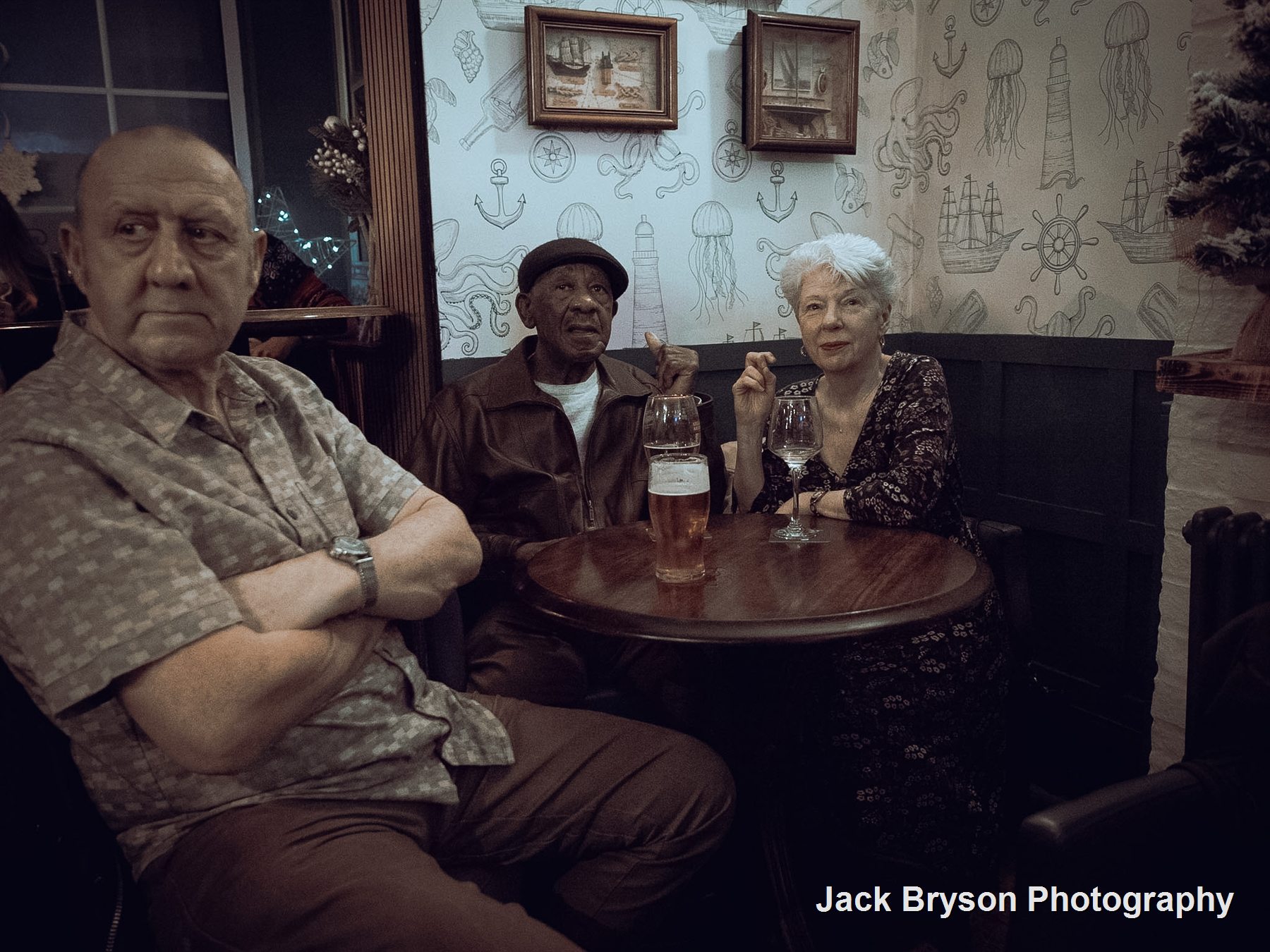 Candid documentary photograph of people seated together in a pub